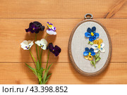 Summer floral hand embroidery with satin ribbons of pansies flowers in hoops on wooden background. Crafts and embroidery as a hobby and leisure. Flat lay, top view, close-up, mock up. Стоковое фото, фотограф Виктория Катьянова / Фотобанк Лори