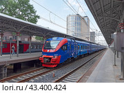 Электропоезд ЭП2Д-0103 «РЭКС. Регион-экспресс» стоит у платформы. Белорусский железнодорожный вокзал в городе Москве (2024 год). Редакционное фото, фотограф Румянцева Наталия / Фотобанк Лори