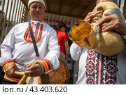 Артисты в традиционных народных костюмах из республики Марий Эл играют на национальных музыкальных инструментах на территории ВДНХ в городе Москве, Россия (2024 год). Редакционное фото, фотограф Николай Винокуров / Фотобанк Лори