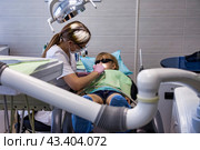 Dental office, woman dentist doing treating teeth little child 5 year old. Kid girl visit dentist doctor having treats teeth in clinic. Medical healthy children dentistry concept. Copy ad text space. Стоковое фото, фотограф Aleksandr Golubev / Фотобанк Лори