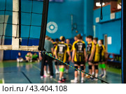 Coach analyze play game of volleyball team, timeout active match in sports school gym. Selective focus of team volleyball game with net. Concept of team sport games success. Copy ad text space. Стоковое фото, фотограф Aleksandr Golubev / Фотобанк Лори