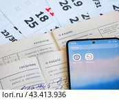 Сведения о заработной плате и стаже в личном кабинете гражданина. Страницы трудовых книжек на фоне календаря и электронные приложения Государственные услуги и Налоги ФЛ. (2024 год). Редакционное фото, фотограф Татьяна Т / Фотобанк Лори