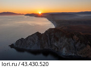 Мыс Нюкля, Охотское море, Магаданская область, Дальний Восток России. Красивый морской пейзаж на закате. Вид с воздуха на скалистый мыс и морской залив. Вечернее солнце над побережьем. Популярная природная туристическая достопримечательность. Стоковое фото, фотограф Андрей Степанов / Фотобанк Лори