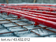 Underfloor heating system in construction of new built residential home. Warm water flooring. Installation close up. Underfloor heating system helixes, flex plumbing pipes on insulation. Construction. Стоковое AI-изображение, AI-художник Марина Демидюк / Фотобанк Лори
