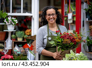 The saleswoman of the flower shop greets customers with a smile. Стоковое AI-изображение, AI-художник Ярославский Максим / Фотобанк Лори