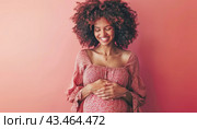 The woman, dressed in pink, is happily caressing her pregnant belly, exuding joy and contentment. Стоковое AI-изображение, AI-художник Юрий Поздников / Фотобанк Лори