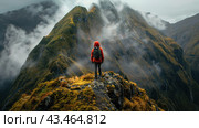 A tourist in a red jacket with a backpack standing on the top of a mountain and looking at the majestic mountain peaks shrouded in clouds and fog. The landscape amazes with its majesty and harsh beauty. The green slopes of the mountains combined with the gray sky create an atmosphere of mystery and adventure. The fog rising from the valleys adds drama and mystery to the picture. This image is ideal for use in the context of themes related to travel, adventure and nature. Стоковое AI-изображение, AI-художник Анна Кривицкая / Фотобанк Лори
