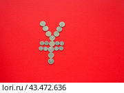 Symbol Yuan of national currency of China is laid out from Chinese Yuan coins on red background. Money transactions, trade and financial concepts. Top view, copy space, mock up, flat lay. Стоковое фото, фотограф Виктория Катьянова / Фотобанк Лори