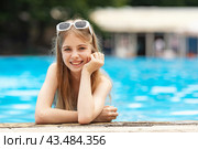 Happy blonde hair teen girl enjoy the sun in hotel swimming pool. Tropical vacation for family with kids, exotic island resort. Water and swim, copy space. Hotel, spa resort advertisement. Стоковое фото, фотограф Ирина Михайличенко / Фотобанк Лори
