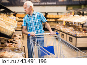 Mature senor choosing bread and baking in grocery section of supermarket. Стоковое фото, фотограф Татьяна Яцевич / Фотобанк Лори