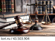 Justice and the law. A wooden hammer, books and scales on the table. The court session. Стоковое AI-изображение, AI-художник Photojuli / Фотобанк Лори