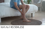 The man's calf muscle cramped, massage of male leg at home. Стоковое видео, видеограф Станислав Тарко / Фотобанк Лори