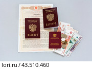 Нотариальная доверенность на получение пенсии пожилого человека, пенсионное удостоверение, паспорта граждан России и российские деньги на светлом столе. Забота о престарелых родственниках (2024 год). Редакционное фото, фотограф Виктория Катьянова / Фотобанк Лори