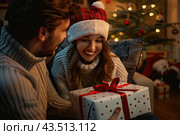 Couple in love with gift for Christmas. Стоковое AI-изображение, AI-художник Ярославский Максим / Фотобанк Лори