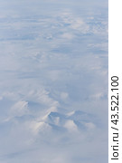 Aerial view of snow-capped mountains and clouds. Winter snowy mountain landscape. Icheghem Range, Kolyma Mountains. Magadan Region, Siberia, Far East of Russia. Great for backgrounds. Стоковое фото, фотограф Андрей Степанов / Фотобанк Лори