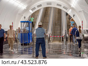 Работник метрополитена в каске наблюдает за эскалаторами. Открытая после реконструкции станция метро «Чернышевская» в Санкт-Петербурге (2024 год). Редакционное фото, фотограф Румянцева Наталия / Фотобанк Лори