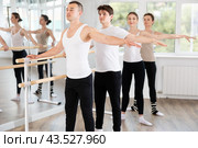Sports young guy in black and white sportswear, participating 2nd position of ballet stance at barre with group in choreography studio. Стоковое фото, фотограф Яков Филимонов / Фотобанк Лори