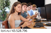 Student are engrossed in their mobile phones, working diligently on their tasks. Стоковое видео, видеограф Яков Филимонов / Фотобанк Лори