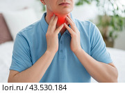 Thyroid gland inflammation, sore throat and cough, man with neck pain on gray background. Стоковое фото, фотограф Станислав Тарко / Фотобанк Лори