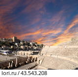 Roman Theatre in Amman, Jordan -- theatre was built the reign of Antonius Pius (138-161 CE), the large and steeply raked structure could seat about 6000 people. Against the sky with clouds (2016 год). Стоковое фото, фотограф Владимир Журавлев / Фотобанк Лори