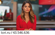 A woman wearing a red dress sits at a news desk and speaks to the camera. Стоковое AI-видео, аниматор Данила Большаков / Фотобанк Лори
