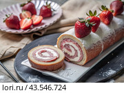 Swiss sponge roll with strawberries, a delicious fruit and cream dessert filled with cream cheese, decorated with fresh strawberries. Стоковое AI-изображение, AI-художник Photojuli / Фотобанк Лори