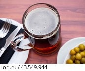 Glass of chilled frothy beer with with delicate green olives. Стоковое фото, фотограф Яков Филимонов / Фотобанк Лори