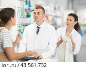Male druggist and his female assistant choosing medicine for client. Стоковое фото, фотограф Яков Филимонов / Фотобанк Лори