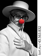 Close-up selective color portrait of sad clown. An elderly man in a white coat and hat. Стоковое фото, фотограф Сергей Пристяжнюк (Serg Zastavkin) / Фотобанк Лори