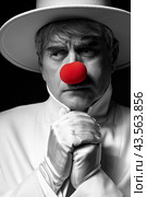 Close-up selective color portrait of sad clown. An elderly man in a white coat and hat. Стоковое фото, фотограф Сергей Пристяжнюк (Serg Zastavkin) / Фотобанк Лори