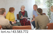 Group of elderly people communicating in English-speaking club with young female tutor. Стоковое видео, видеограф Яков Филимонов / Фотобанк Лори