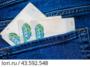 Деньги. Рублевые купюры номиналом в 1000 в кармане. Стоковое фото, фотограф E. O. / Фотобанк Лори
