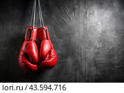 Professional red boxing gloves hang on a black background with a space to copy. Стоковое AI-изображение, AI-художник Photojuli / Фотобанк Лори