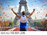 A track and field athlete won during a marathon or race against the backdrop of the Eiffel Tower at a sporting event. The concept of the Summer Olympic Games. Стоковое AI-изображение, AI-художник Photojuli / Фотобанк Лори