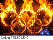 A fire show. The burning rings of the Olympic Sports Games. Стоковое AI-изображение, AI-художник Photojuli / Фотобанк Лори