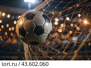 Goal. A soccer ball in the goal net, against a background of sparkling lights and a blurred background. Стоковое AI-изображение, AI-художник Photojuli / Фотобанк Лори
