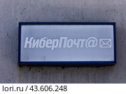 Табличка с надписью "КиберПочт@" (пункт коллективного доступа в Интернет) висит на фасаде здания отделения Почты России в сельской местности. Россия (2024 год). Редакционное фото, фотограф Николай Винокуров / Фотобанк Лори