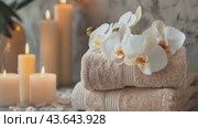 A stack of towels adorned with flowers and candles is elegantly arranged on a table. Стоковое AI-видео, аниматор Юрий Поздников / Фотобанк Лори