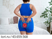 Tailbone pain, coccyx fracture, woman suffering from coccygodynia at home. Стоковое фото, фотограф Станислав Тарко / Фотобанк Лори