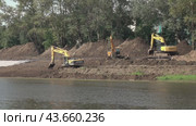 Construction heavy machinery on the river Bank within the city limits. (2019 год). Редакционное видео, видеограф Андрей Шалари / Фотобанк Лори
