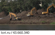 Construction heavy machinery on the river Bank within the city limits. (2019 год). Редакционное видео, видеограф Андрей Шалари / Фотобанк Лори