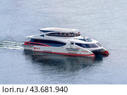 Krasnoyarsk, Russia, July 27, 2024. Electric cruise catamaran on the Yenisei River close-up. A sleek, modern catamaran ferrying passengers through tranquil waters, capturing a moment of serene travel. Редакционное фото, фотограф Владимир Разгуляев / Фотобанк Лори