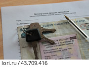Ключи от автомобиля и ручка лежат на свидетельстве о регистрации и паспорте ТС с договором купли-продажи автомобиля. Стоковое фото, фотограф Ирина Григорьева / Фотобанк Лори