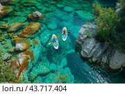 Two Kayakers Adventuring Through Crystal Clear Waters in a Scenic Lake Surrounded by Breathtaking Nature. Стоковое AI-изображение, AI-художник Сергей Толмачёв / Фотобанк Лори