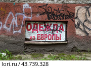Объявление с надписью "Одежда из Европы" на фасаде здания в городе Калининград, Россия (2024 год). Редакционное фото, фотограф Николай Винокуров / Фотобанк Лори