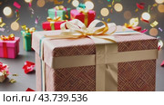 A beautiful pink gift box adorned with a shiny gold bow is surrounded by several other gifts nearby. Стоковое AI-видео, аниматор Юрий Поздников / Фотобанк Лори