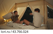 Pillow fight. The lovers are playing around in their tent at the campsite. Стоковое видео, видеограф Strunov David / Фотобанк Лори