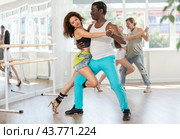 Woman dances incendiary tango with African man partner during choreography lesson. Стоковое фото, фотограф Яков Филимонов / Фотобанк Лори