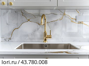 Kitchen sink. Modern new gold faucet, marble countertop. Stylish white sink, Brass faucets in light interior. Golden tap. Domestic Appliances. Gray clean bright household equipment. Contemporary style. Стоковое AI-изображение, AI-художник Марина Демидюк / Фотобанк Лори