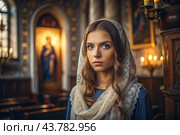 Portrait of a beautiful young woman in a headscarf in an Orthodox church. A girl prays in a church against the background of icons. Стоковое AI-изображение, AI-художник Photojuli / Фотобанк Лори